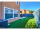 Private backyard featuring an artificial lawn and a tall, dark blue block fence for enhanced privacy at 2994 E Megan St, Gilbert, AZ 85295
