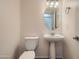 Cozy powder room featuring pedestal sink, oval mirror, and neutral decor at 2994 E Megan St, Gilbert, AZ 85295