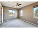 Neutral bedroom featuring a ceiling fan, multiple windows that provide an abundance of natural light, and carpet flooring at 2994 E Megan St, Gilbert, AZ 85295