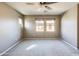 Neutral bedroom with ceiling fan and two large windows bringing in natural light at 2994 E Megan St, Gilbert, AZ 85295