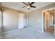 Spacious bedroom featuring a ceiling fan, plush carpet and access to a closet and hallway at 2994 E Megan St, Gilbert, AZ 85295