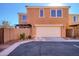 Beige two-story home showing a closed garage door, brick landscaping, and a bright blue sky at 2994 E Megan St, Gilbert, AZ 85295