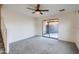 Spacious living room with neutral carpet, a ceiling fan, and sliding door access at 2994 E Megan St, Gilbert, AZ 85295