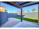 Backyard patio featuring pavers, artificial grass, a gray block fence, and a wood-covered pergola at 2994 E Megan St, Gilbert, AZ 85295
