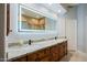 The bathroom has a lighted mirror, dual sinks, granite countertops, and dark wood cabinetry at 32472 N 68Th Pl, Scottsdale, AZ 85266
