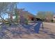 Inviting community entrance featuring a covered porte cochere, desert landscaping, and brick-paved driveway at 32472 N 68Th Pl, Scottsdale, AZ 85266
