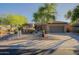 Charming single-story home with desert landscaping, mature trees, and a spacious driveway at 32472 N 68Th Pl, Scottsdale, AZ 85266
