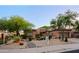 Attractive single-story home featuring desert landscaping, stone accents, and mature trees at 32472 N 68Th Pl, Scottsdale, AZ 85266
