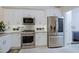 A modern kitchen featuring stainless steel appliances, white cabinets and light countertops at 32472 N 68Th Pl, Scottsdale, AZ 85266