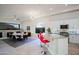 Open-concept kitchen and dining area with modern lighting, granite countertops and red bar stools at 32472 N 68Th Pl, Scottsdale, AZ 85266