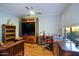 Well-lit home office featuring hardwood floors, custom wood cabinets, and a ceiling fan at 32472 N 68Th Pl, Scottsdale, AZ 85266