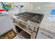 Close-up of the stainless steel gas range and oven with light backsplash and granite counter at 32472 N 68Th Pl, Scottsdale, AZ 85266