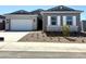 Charming single-story home featuring a brick and wood facade, a two-car garage, and desert landscaping at 35524 N Tin Ct, San Tan Valley, AZ 85144
