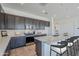 Modern kitchen features sleek dark cabinetry, stainless steel appliances, and a spacious island with bar seating at 35524 N Tin Ct, San Tan Valley, AZ 85144