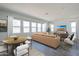 Bright living room with large windows, a comfortable sectional sofa, and a stylish dining area at 35524 N Tin Ct, San Tan Valley, AZ 85144
