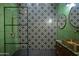 Elegant bathroom showcasing tiled accent wall, walk-in shower with glass door, and modern gold vanity at 358 E Whitton Ave, Phoenix, AZ 85012