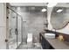 Modern bathroom featuring decorative tile, glass shower, floating vanity, and stylish round mirror at 358 E Whitton Ave, Phoenix, AZ 85012