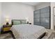 Bright bedroom featuring hardwood floors, light walls, modern lamps, and frosted glass closet at 358 E Whitton Ave, Phoenix, AZ 85012