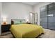 Modern bedroom with hardwood floors, bedside tables, a minimalist closet, and stylish lamps at 358 E Whitton Ave, Phoenix, AZ 85012