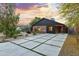Charming single-story home with red brick and modern siding, well-manicured yard, and a long concrete driveway with grass accents at 358 E Whitton Ave, Phoenix, AZ 85012