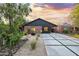Charming single-story home with red brick and modern siding, well-manicured yard, and a concrete driveway with grass accents at 358 E Whitton Ave, Phoenix, AZ 85012