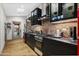 Kitchen featuring exposed brick wall, black cabinetry, stainless appliances and unique laundry setup at 358 E Whitton Ave, Phoenix, AZ 85012