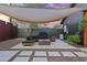 Modern outdoor patio featuring a built-in seating area, fire pit, and shade canopy at 358 E Whitton Ave, Phoenix, AZ 85012