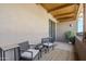 Relaxing outdoor balcony space with woven chairs, side tables, and a stylish area rug at 36601 N Mule Train Rd # D1, Carefree, AZ 85377