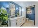 Bathroom featuring double sinks with chrome fixtures, contemporary lighting and blue accent wall at 36601 N Mule Train Rd # D1, Carefree, AZ 85377