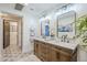 Elegant bathroom with a double sink vanity, stylish mirrors, and patterned tile flooring at 36601 N Mule Train Rd # D1, Carefree, AZ 85377