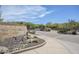 The Village at Carefree entrance featuring desert landscaping, rock signage, and a secure gate for privacy at 36601 N Mule Train Rd # D1, Carefree, AZ 85377