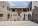 Southwestern-style courtyard featuring tan stucco walls, desert landscaping, and gated entrances at 36601 N Mule Train Rd # D1, Carefree, AZ 85377