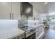 Kitchen with white cabinets, marble countertops, stainless steel range, and backsplash at 36601 N Mule Train Rd # D1, Carefree, AZ 85377