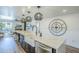 Kitchen island with marble countertop, white farmhouse sink, modern lighting, and black bar stools at 36601 N Mule Train Rd # D1, Carefree, AZ 85377