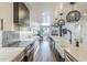 Bright kitchen with white cabinets, marble countertops, stainless steel appliances, and modern lighting at 36601 N Mule Train Rd # D1, Carefree, AZ 85377