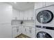 Efficient laundry area equipped with modern, stacked washer and dryer units, and ample storage with white cabinetry at 36601 N Mule Train Rd # D1, Carefree, AZ 85377