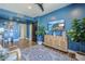 Stylish living room featuring blue walls, modern decor, and a view into the hallway at 36601 N Mule Train Rd # D1, Carefree, AZ 85377