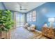 Bright living room with blue walls, wood floors, stylish furniture, and natural light at 36601 N Mule Train Rd # D1, Carefree, AZ 85377