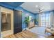 Comfortable blue-walled living room with wood floors, a sliding barn door, and a balcony view at 36601 N Mule Train Rd # D1, Carefree, AZ 85377