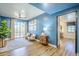 Bright and airy living room with blue walls, wood floors, and a picturesque balcony view at 36601 N Mule Train Rd # D1, Carefree, AZ 85377