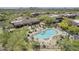 Aerial shot of a community pool with desert landscaping, lounge chairs, umbrellas and various seating areas at 36601 N Mule Train Rd # D1, Carefree, AZ 85377