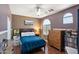 Cozy bedroom featuring wood-look floors, a ceiling fan, and an arched window with natural light at 3679 S Cottonwood Ct, Chandler, AZ 85286