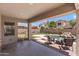 Covered patio overlooking a serene pool with rock features and a relaxing fire pit area at 3679 S Cottonwood Ct, Chandler, AZ 85286