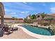 Relaxing backyard oasis with a sparkling pool, rock waterfall, and patio seating at 3679 S Cottonwood Ct, Chandler, AZ 85286
