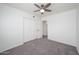 A simple, carpeted bedroom with a ceiling fan features a double door closet and an interior door at 3755 E Broadway Rd # 21, Mesa, AZ 85206