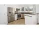 A modern kitchen featuring stainless steel appliances, tiled backsplash, white cabinetry and tiled floor at 3755 E Broadway Rd # 21, Mesa, AZ 85206