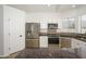 Modern kitchen with stainless steel appliances, breakfast bar, tiled backsplash and white cabinetry at 3755 E Broadway Rd # 21, Mesa, AZ 85206