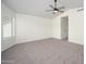 A large, carpeted main bedroom with a ceiling fan has one window with blinds and a view to the backyard at 3755 E Broadway Rd # 21, Mesa, AZ 85206