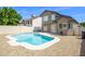 A backyard pool with a pebble rock surround is set against a wall and the back of a brown, two-story house at 3755 E Broadway Rd # 21, Mesa, AZ 85206