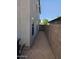 Narrow gravel side yard with block wall, gate, and stucco house wall at 4613 W Fawn Dr, Laveen, AZ 85339